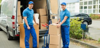 Two-Happy-Male-movers-In-Front-Of-Truck-With-Stack-Of-Cardboard-Boxes-42192582_xxl-1024x683